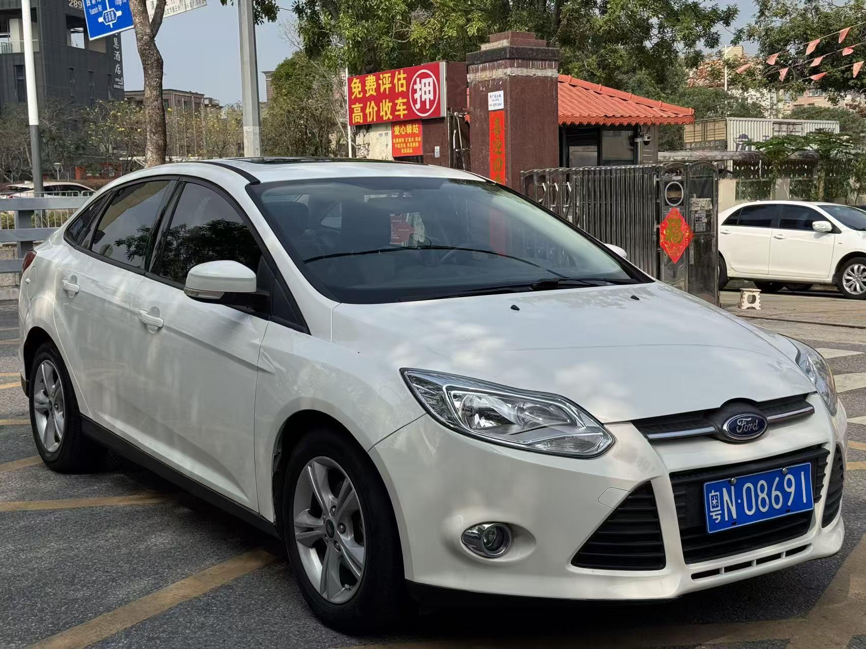 Ford Focus 2012 front three-quarter view - white compact sedan